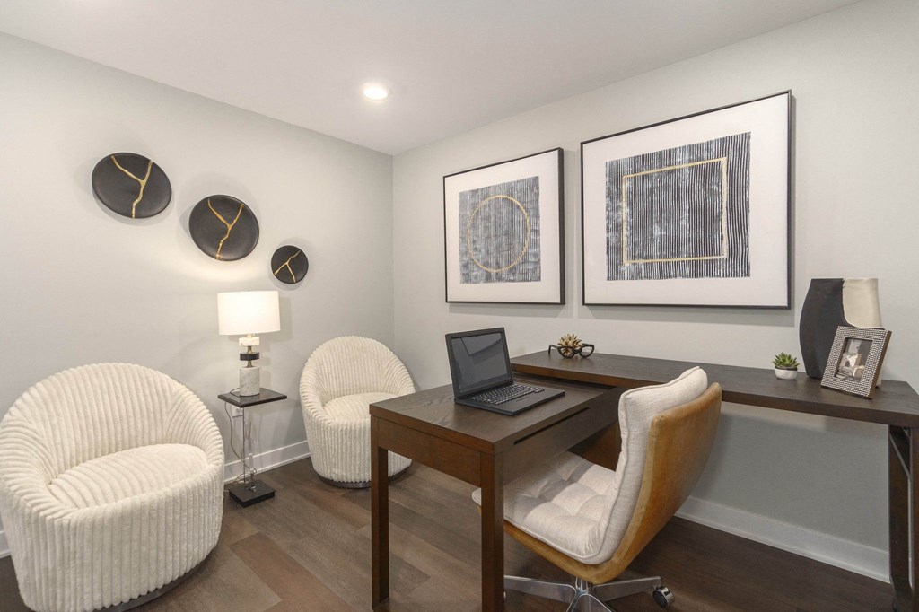 a home office with two chairs and a desk with a laptop